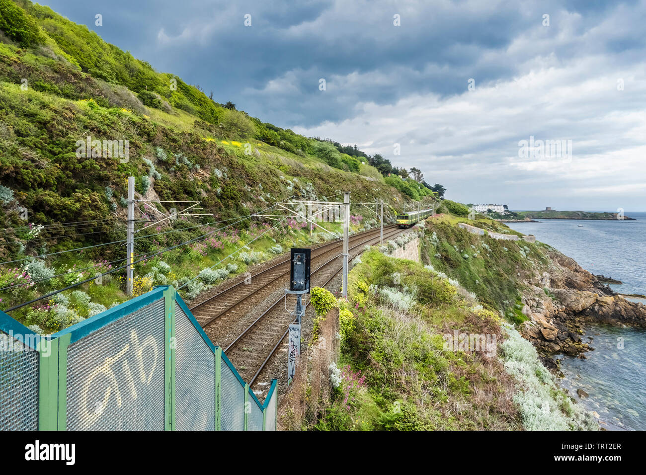 Railway track beside Killiney Bay, County Dublin, Ireland with Dublin DART train approaching Killiney from the north Stock Photo