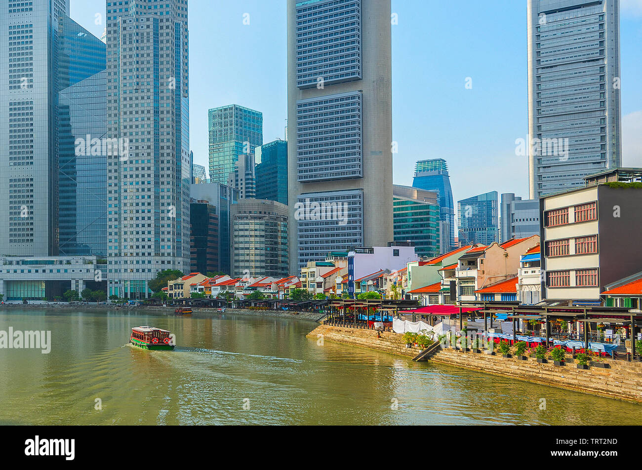 Touristic boat by the river at famous Boat Quay district, Singapore Stock Photo