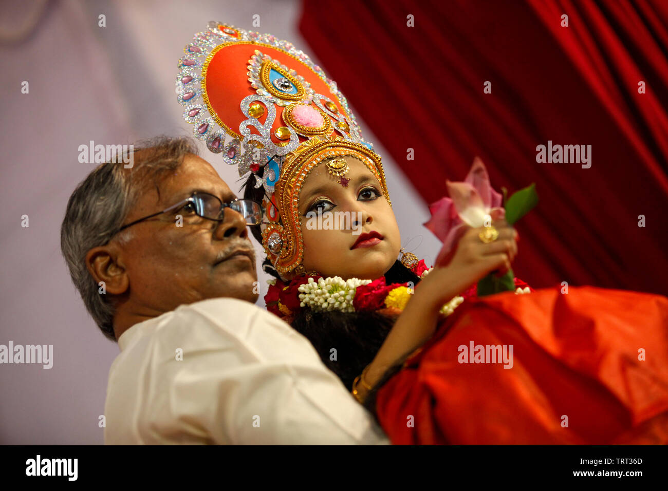 A young girl sits for the 'Kumari Puja' ritual at the Ramkrishna Mission temple in Dhaka. Kumari Puja is a part of Durga Puja festival where a young g Stock Photo
