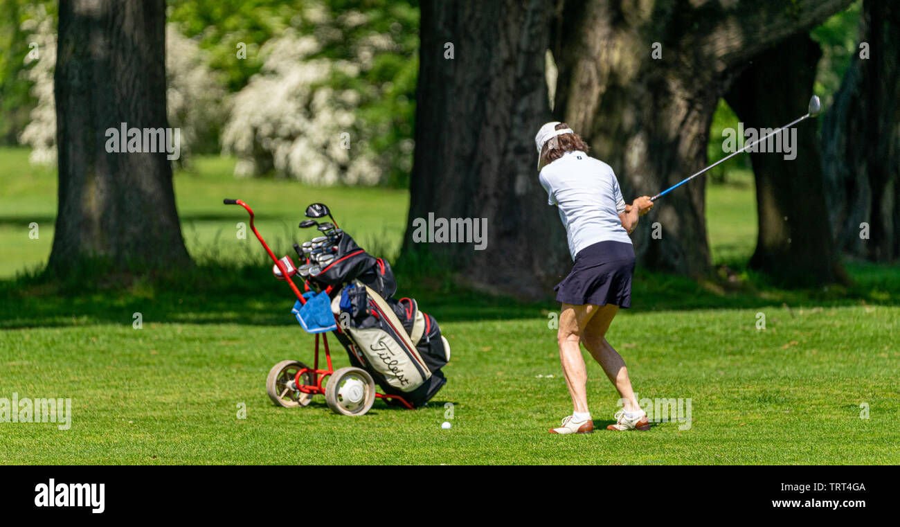 Braunschweig, Germany, May 18, 2019: Middle-aged woman hitting the golf ball over the green at the German Golf Association's golf tournament Stock Photo