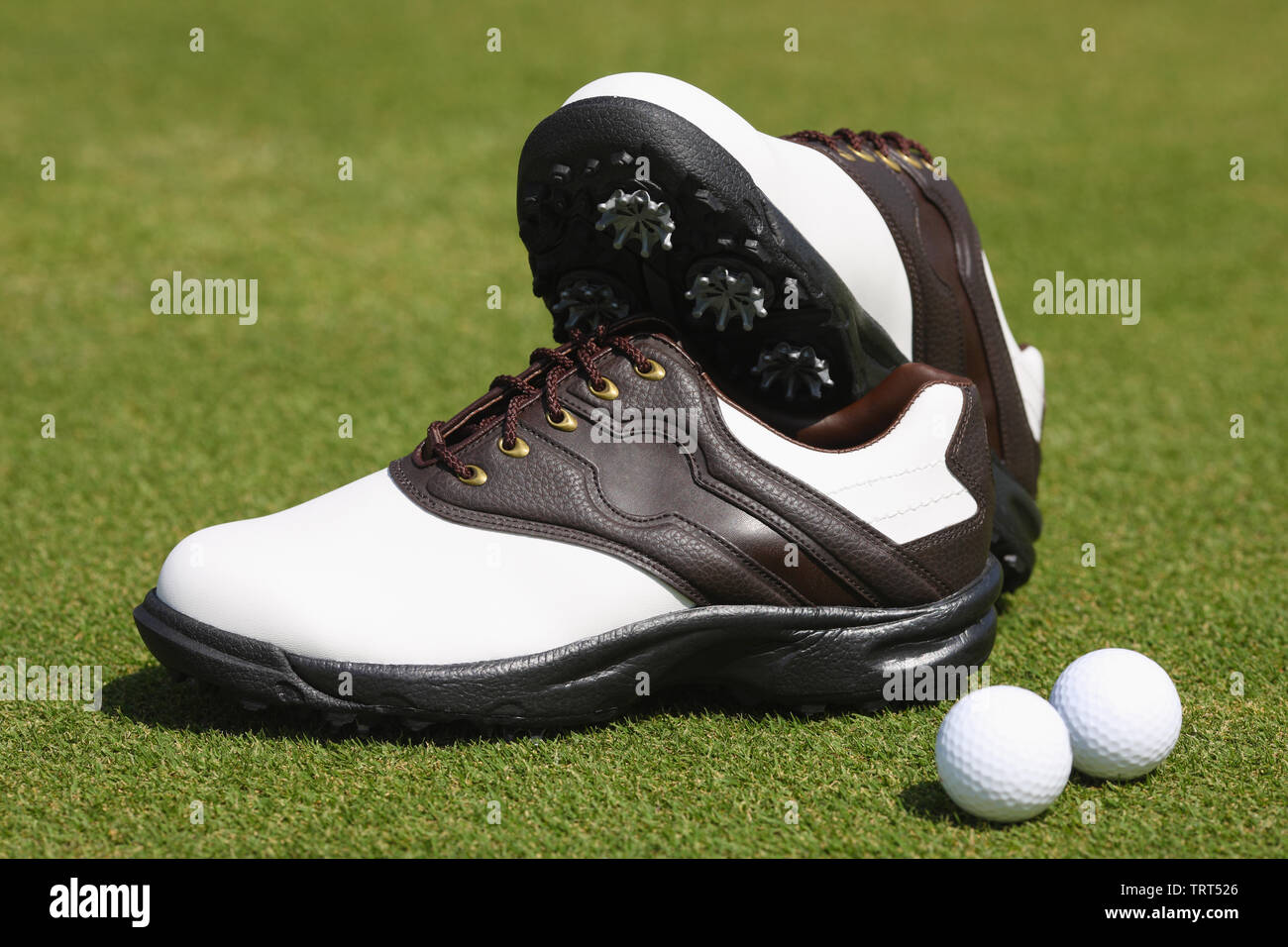Pair of golf shoes and two golf balls on grass Stock Photo