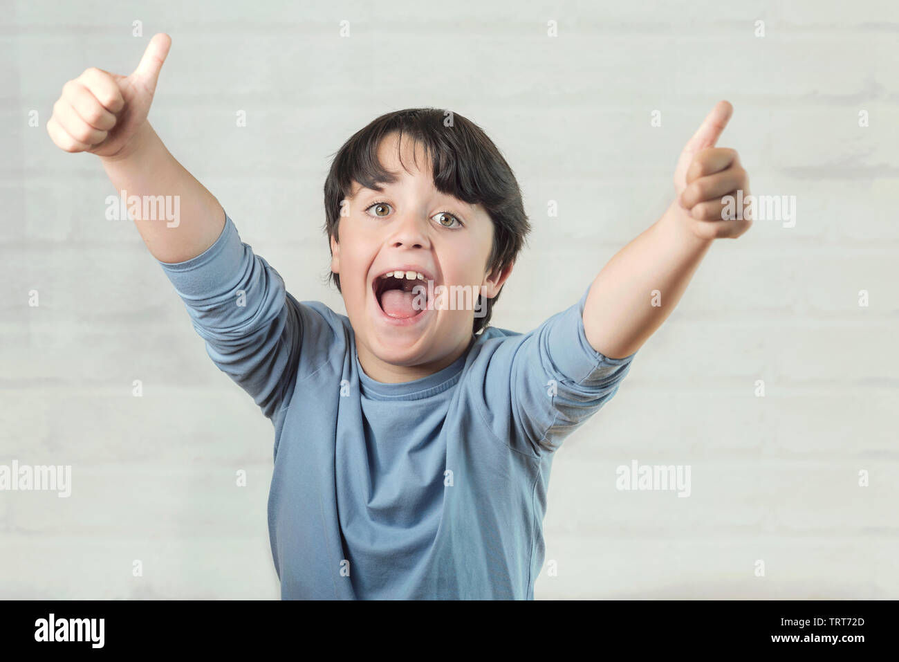 Little boy smiling showing thumbs up on brick background Stock Photo ...