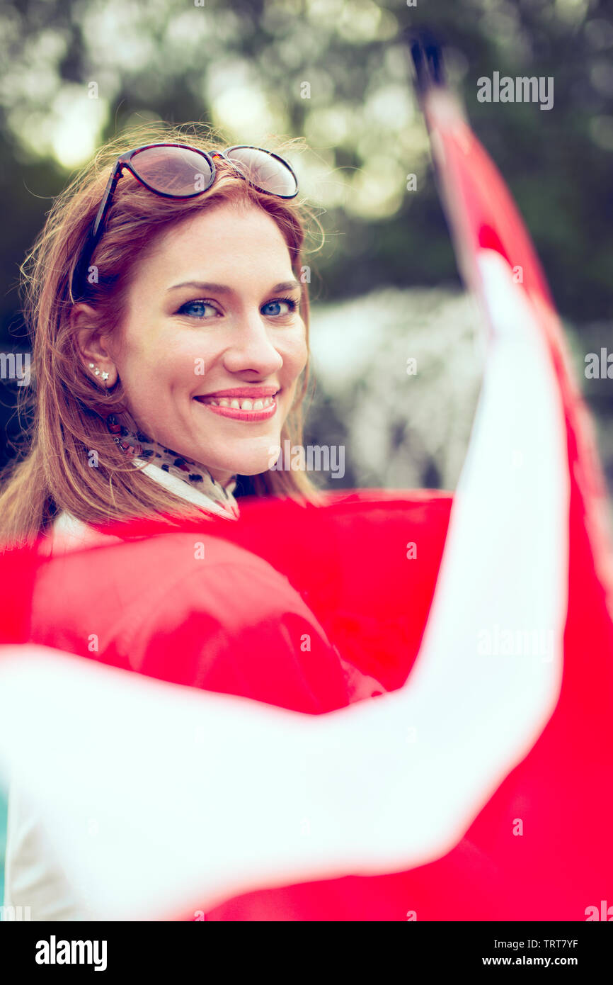 Happy young woman with smile holding flag of Austria in park Stock Photo
