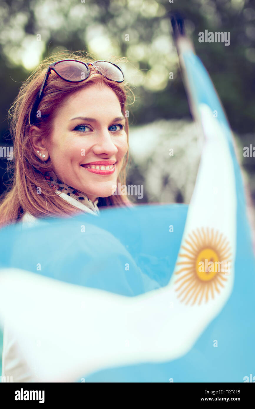 Happy young woman with smile holding flag of Argentina in park Stock Photo