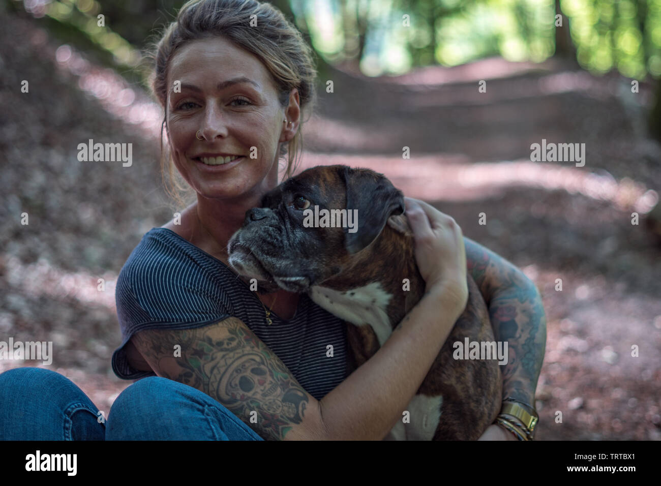 woman and her dog cuddling in a forest Stock Photo