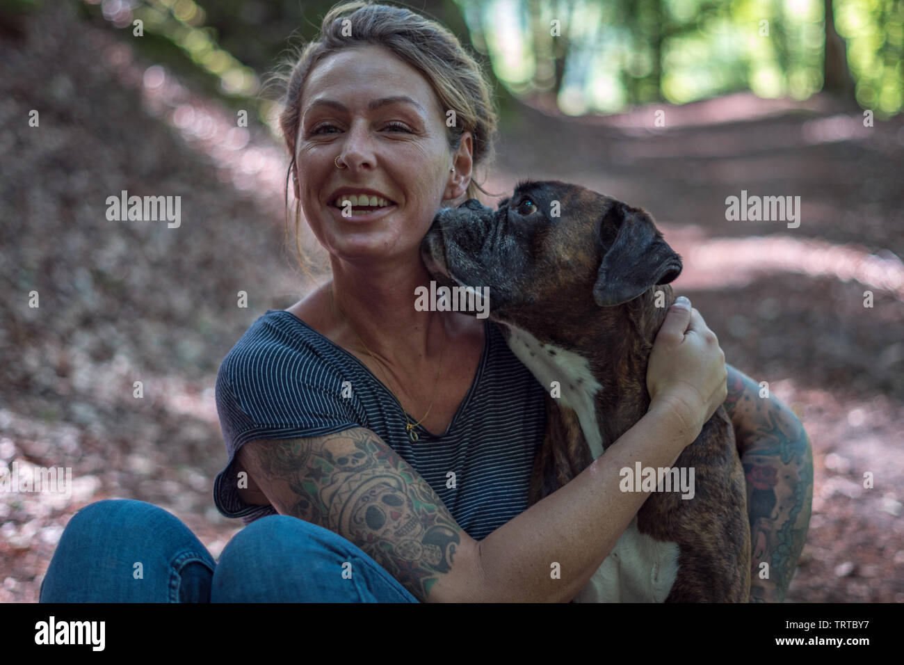 woman and her dog cuddling in a forest Stock Photo