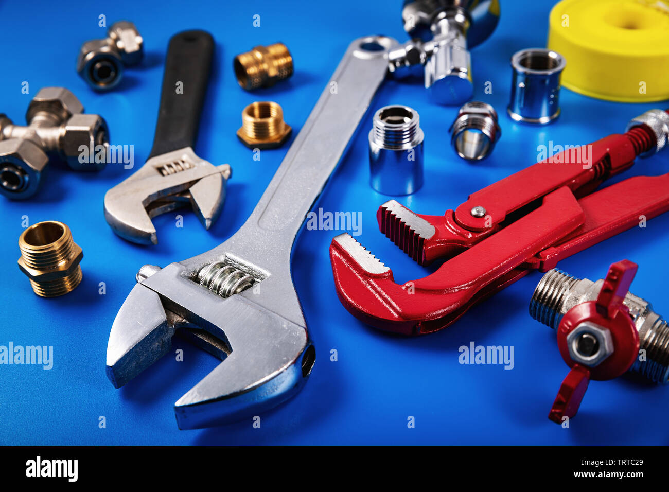 plumbing tools and fittings on blue background Stock Photo
