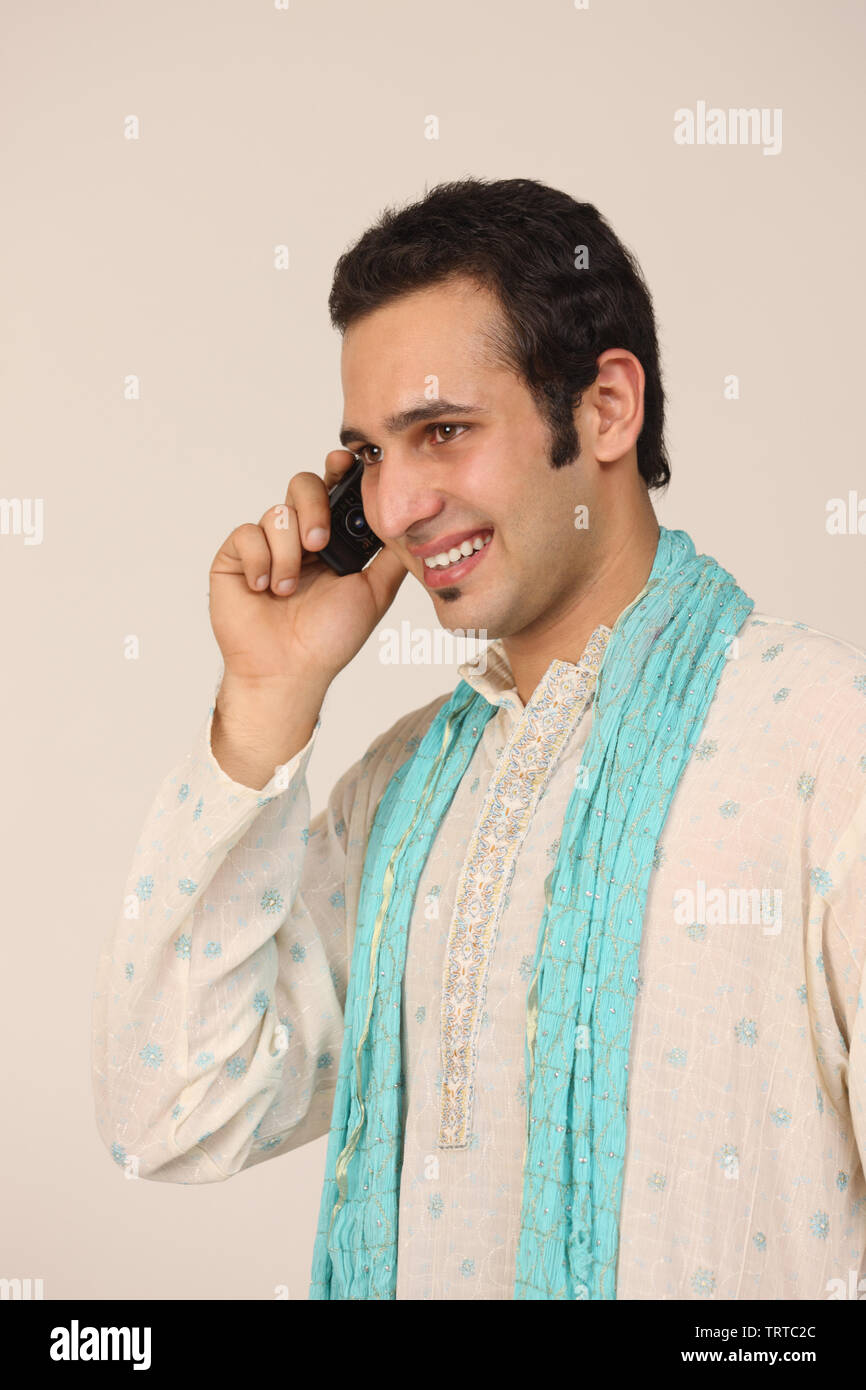 Indian man talking on a mobile phone and smiling Stock Photo - Alamy
