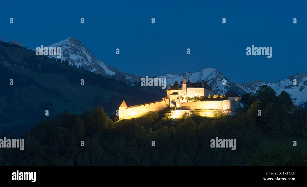 Gruyere, VD / Switzerland - 31 May 2019:  view the historic castle at Gruyere with snowcapped mountain landscape at twilight Stock Photo