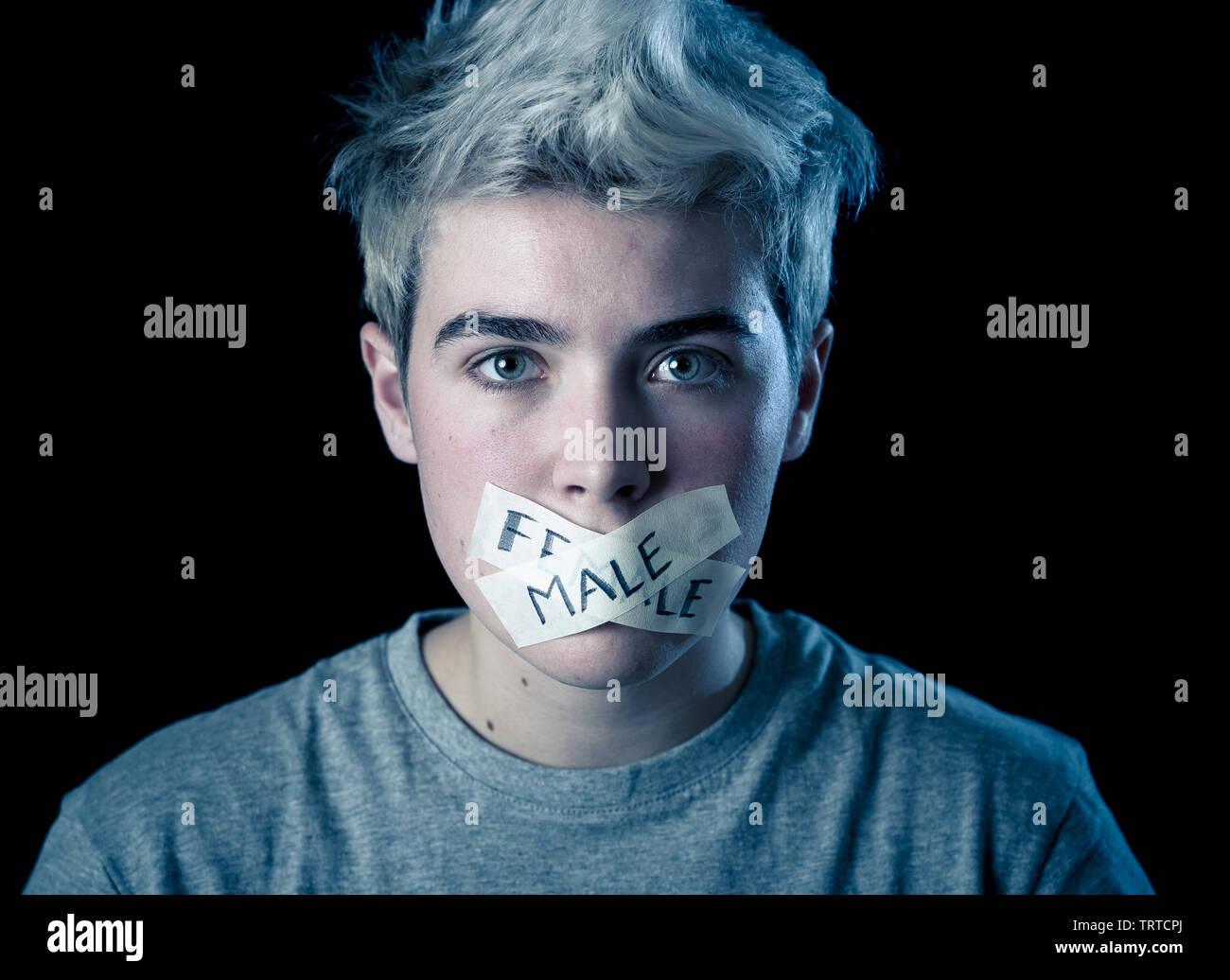 Transgender teenager with mouth sealed on tape with words male and female written in social
