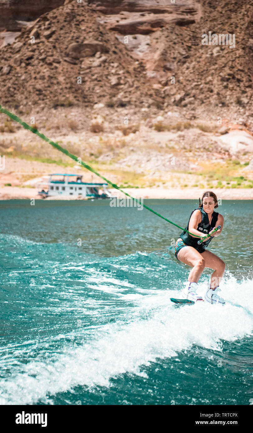 Young strong and gorgeous woman wakeboarding around Lake Powell on a ...