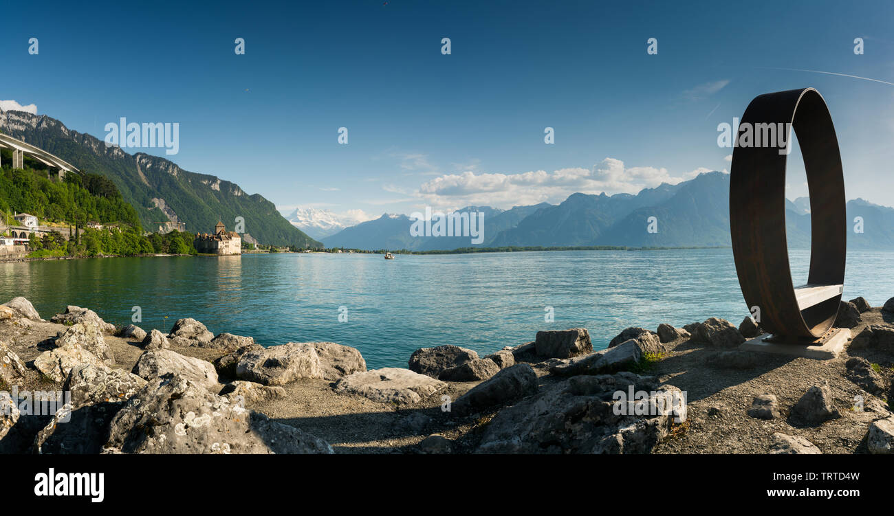 Territet, VD / Switzerland - 31 May 2019: panorama landscape of Lake Geneva with Chillon Castle and Territet Harbor and sculpture and motorway Stock Photo