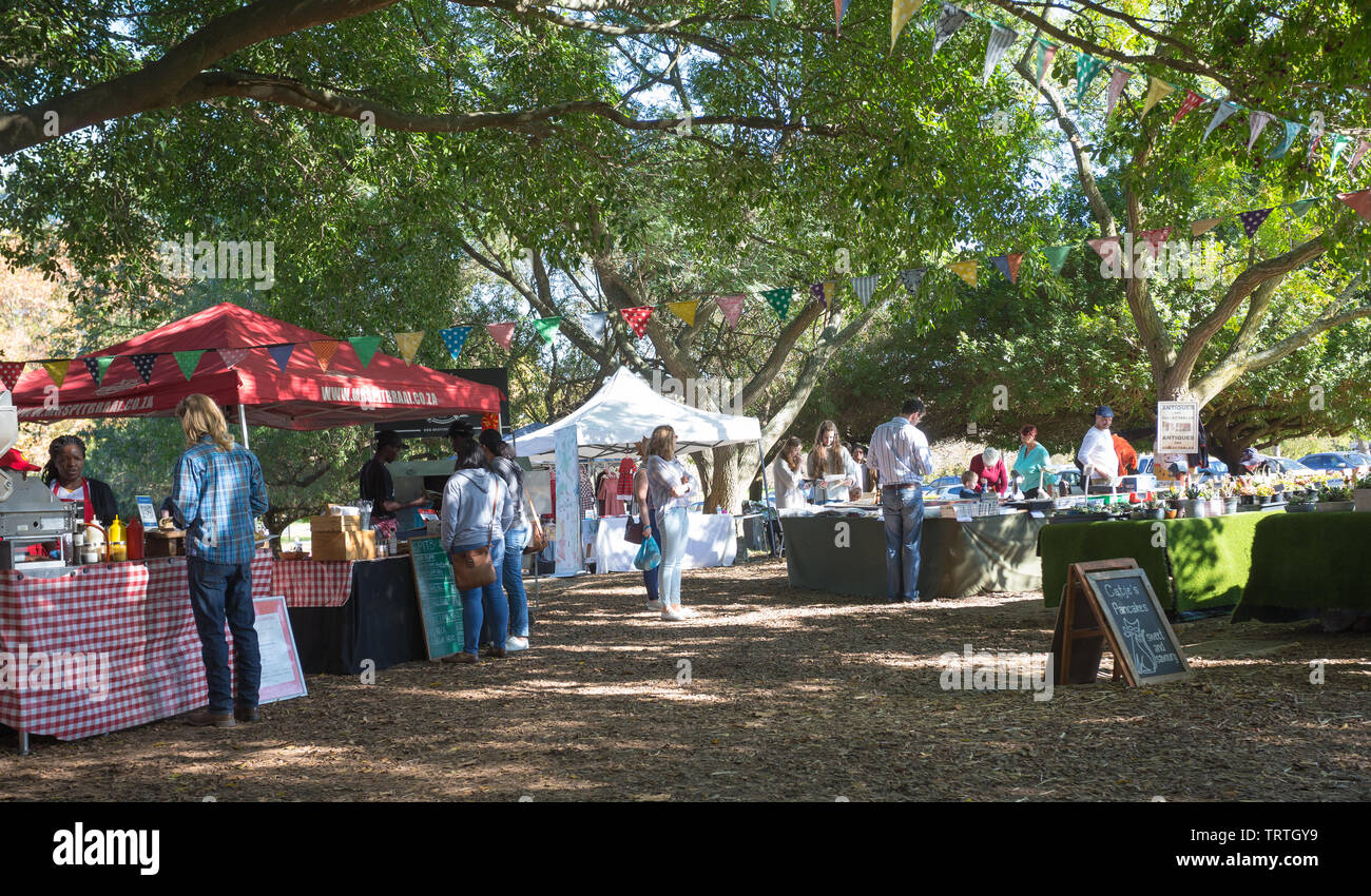people enjoying an outdoor market under the trees on an Autumn day in Stellenbosch at Blaauwklippen wine estate, Cape Winelands, South Africa Stock Photo