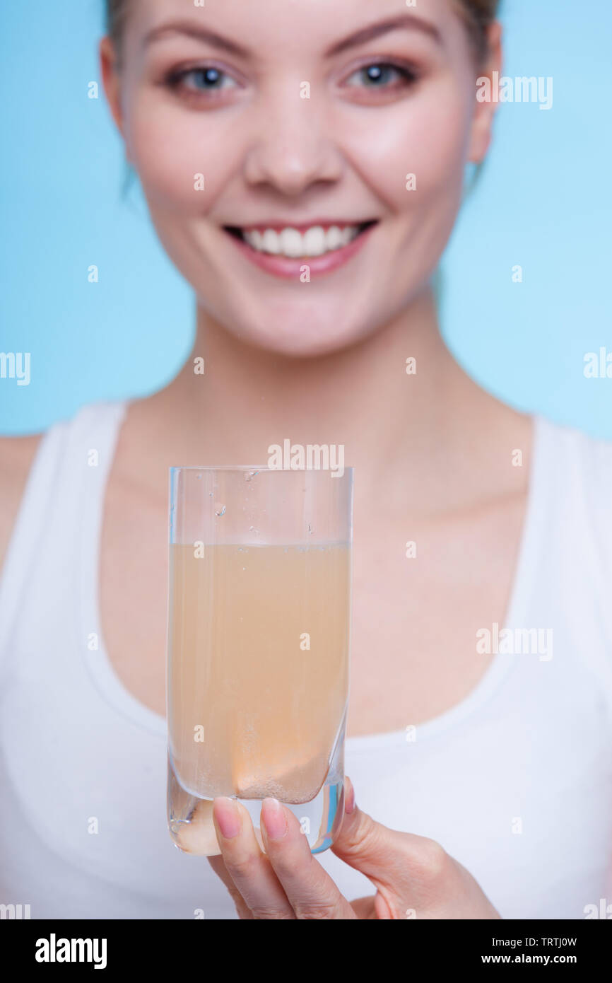 Vitamins, health, medicines. Woman holding glass with orange flavored