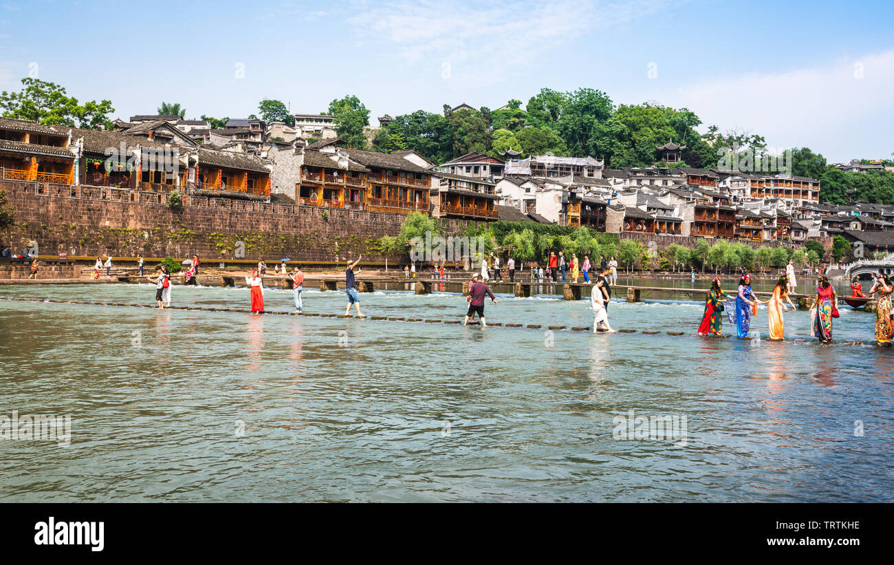 2 June 2019, Fenghuang China : Chinese tourists on bridge over Tuo Jiang river and old fortification in background in phoenix ancient town in Hunan Ch Stock Photo