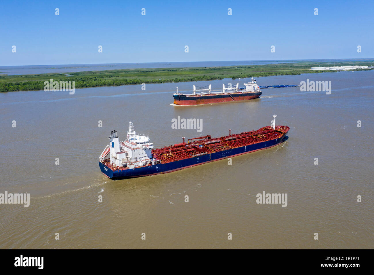 Empire, Louisiana - Ships on the Mississippi River below New Orleans. The Liberian oil/chemical tanker Tintomara (foreground) sails towards the Gulf o Stock Photo