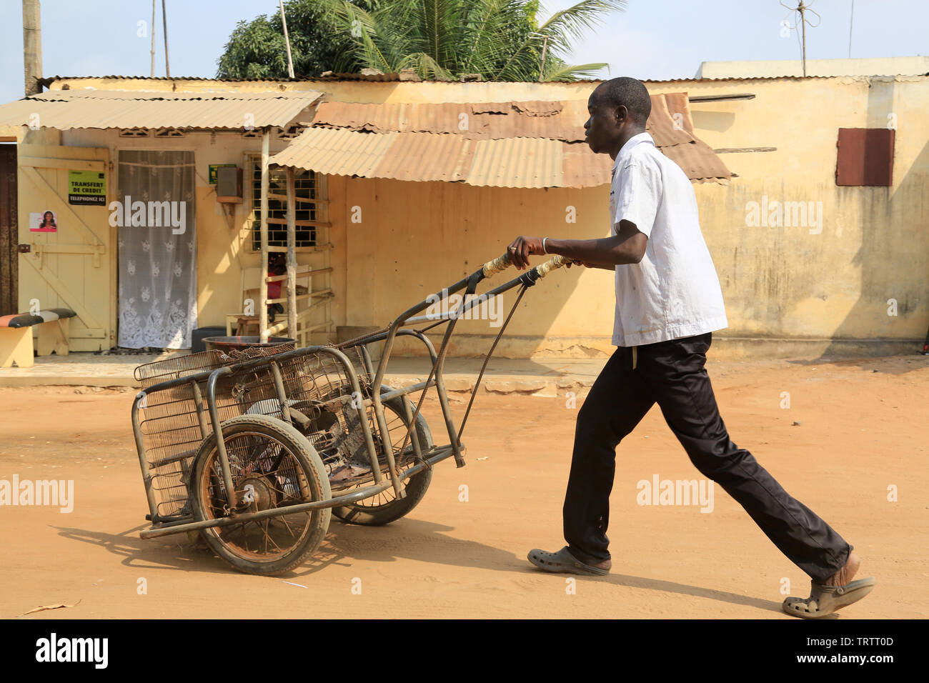 Togolais poussant une charrette. Lomé. Togo. Afrique de l'Ouest. Stock Photo
