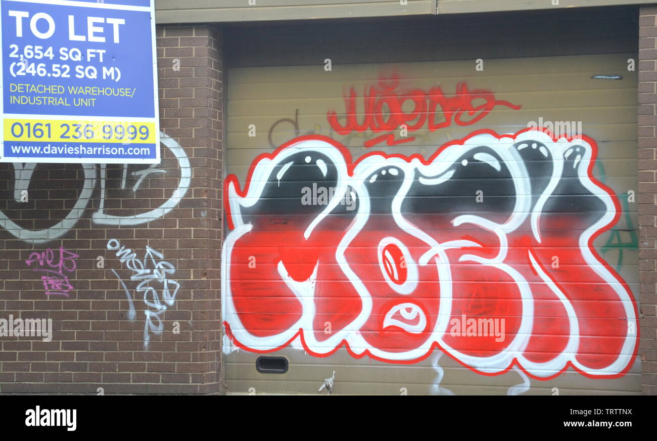 Graffiti on commercial buildings in South Manchester. The United Kingdom spends over £1 billion a year on removing graffiti. Image shows graffiti on an unlet commercial unit in Manchester, uk Stock Photo