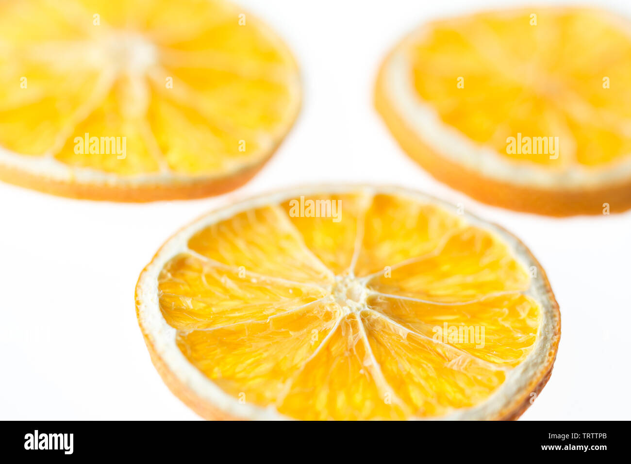 Three dried orange slices isolated on white background - selective focus Stock Photo