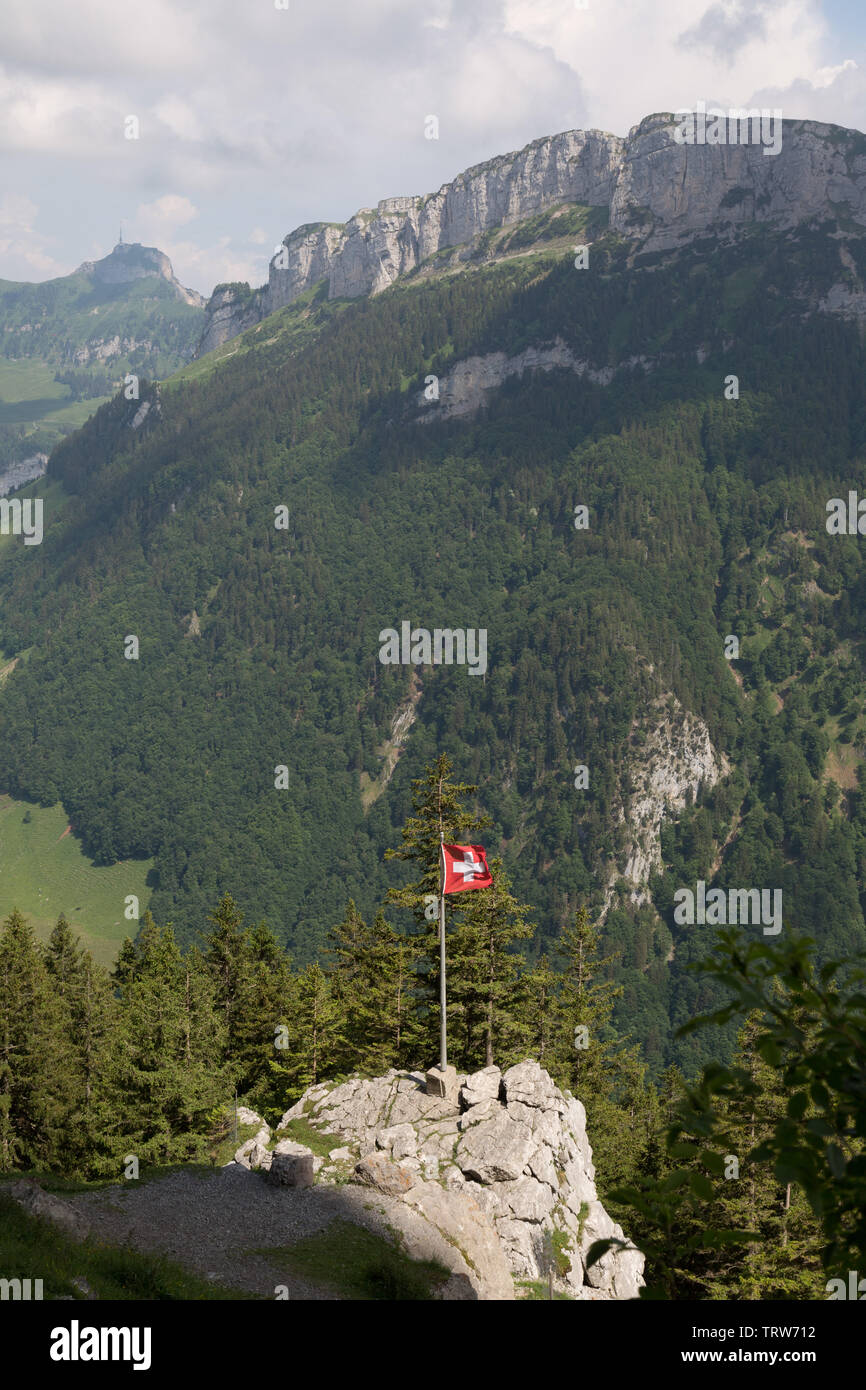 A Swiss flag flies among the Appenzell Alps at Ebenalp, Switzerland. Stock Photo