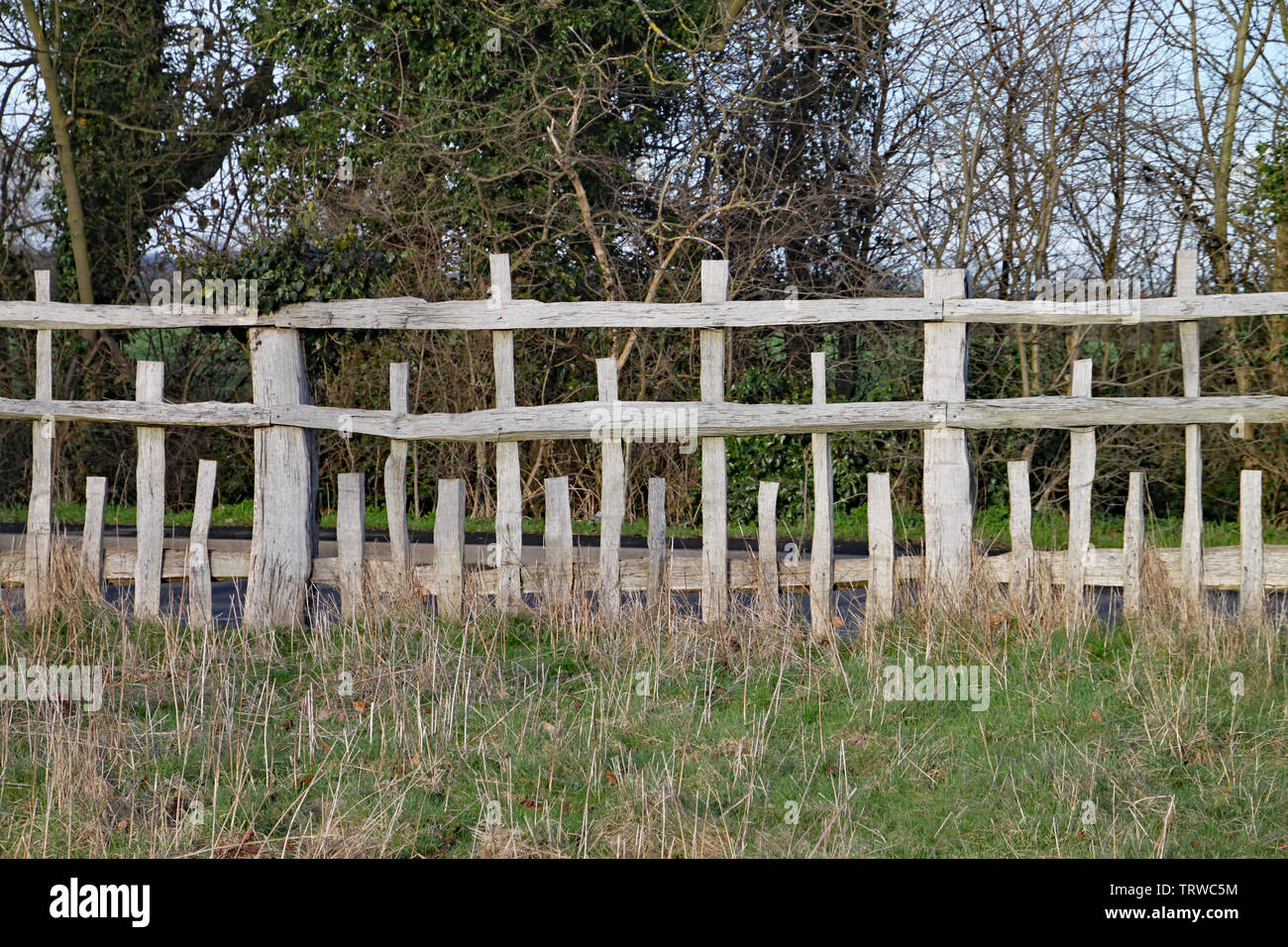 Unusual wooden fence with parallel horizontal rails and vertical posts