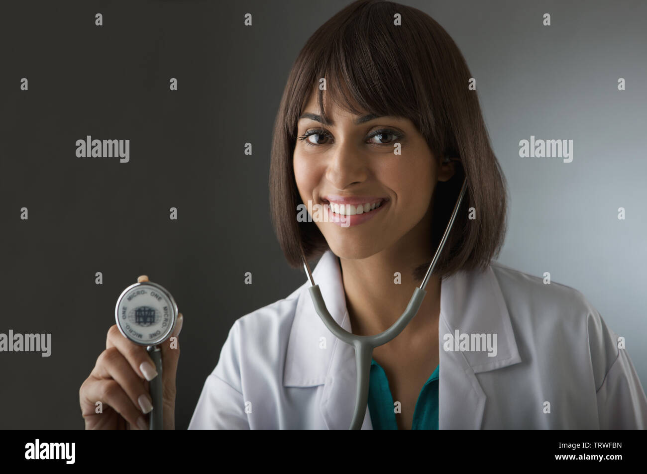 Female doctor using stethoscope and smiling Stock Photo - Alamy