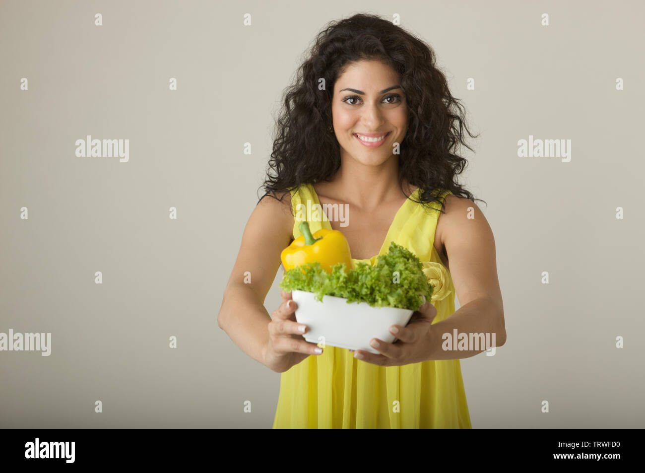 Woman holding a bowl of vegetables and smiling Stock Photo