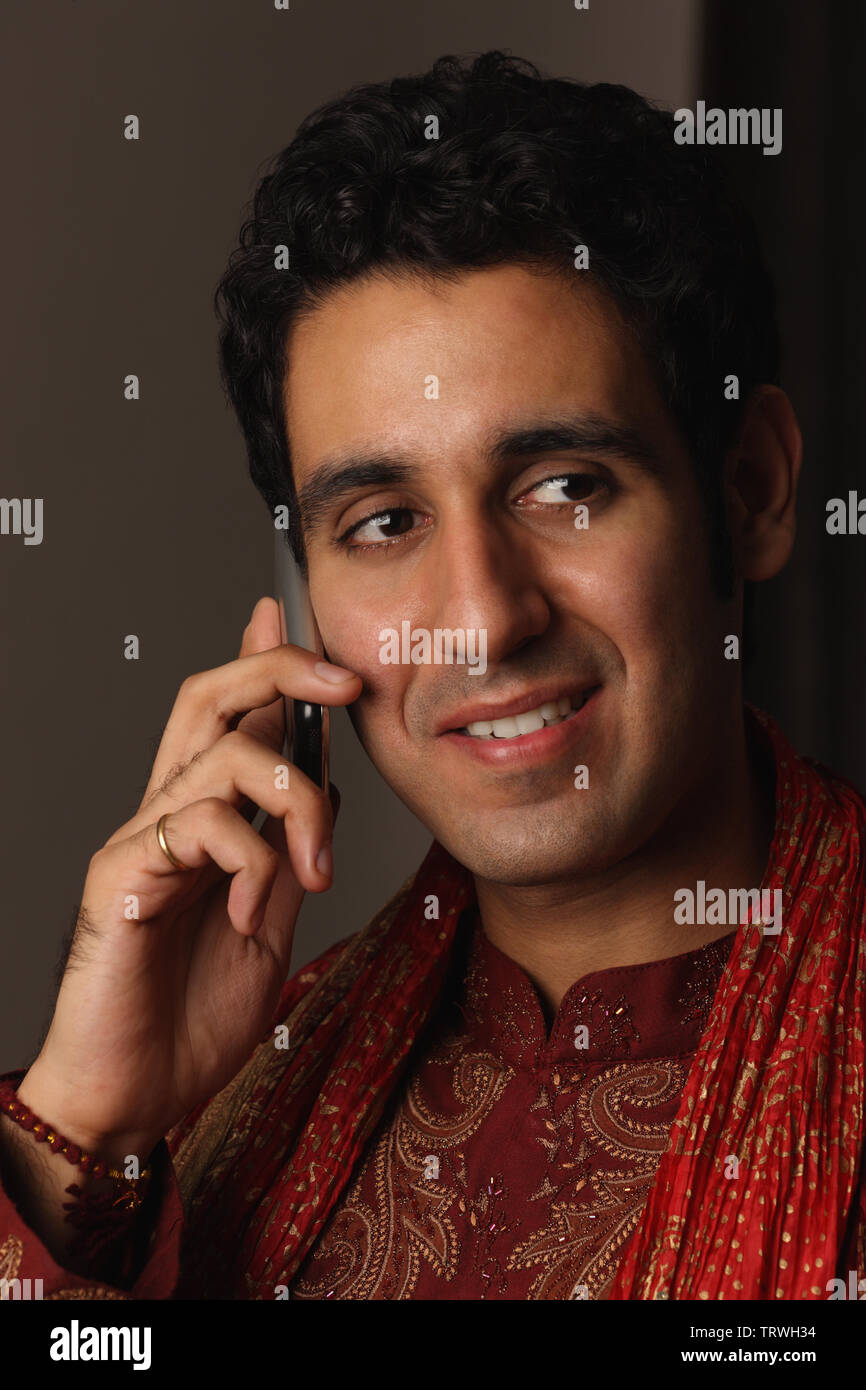 Indian man talking on a mobile phone and smiling Stock Photo Alamy