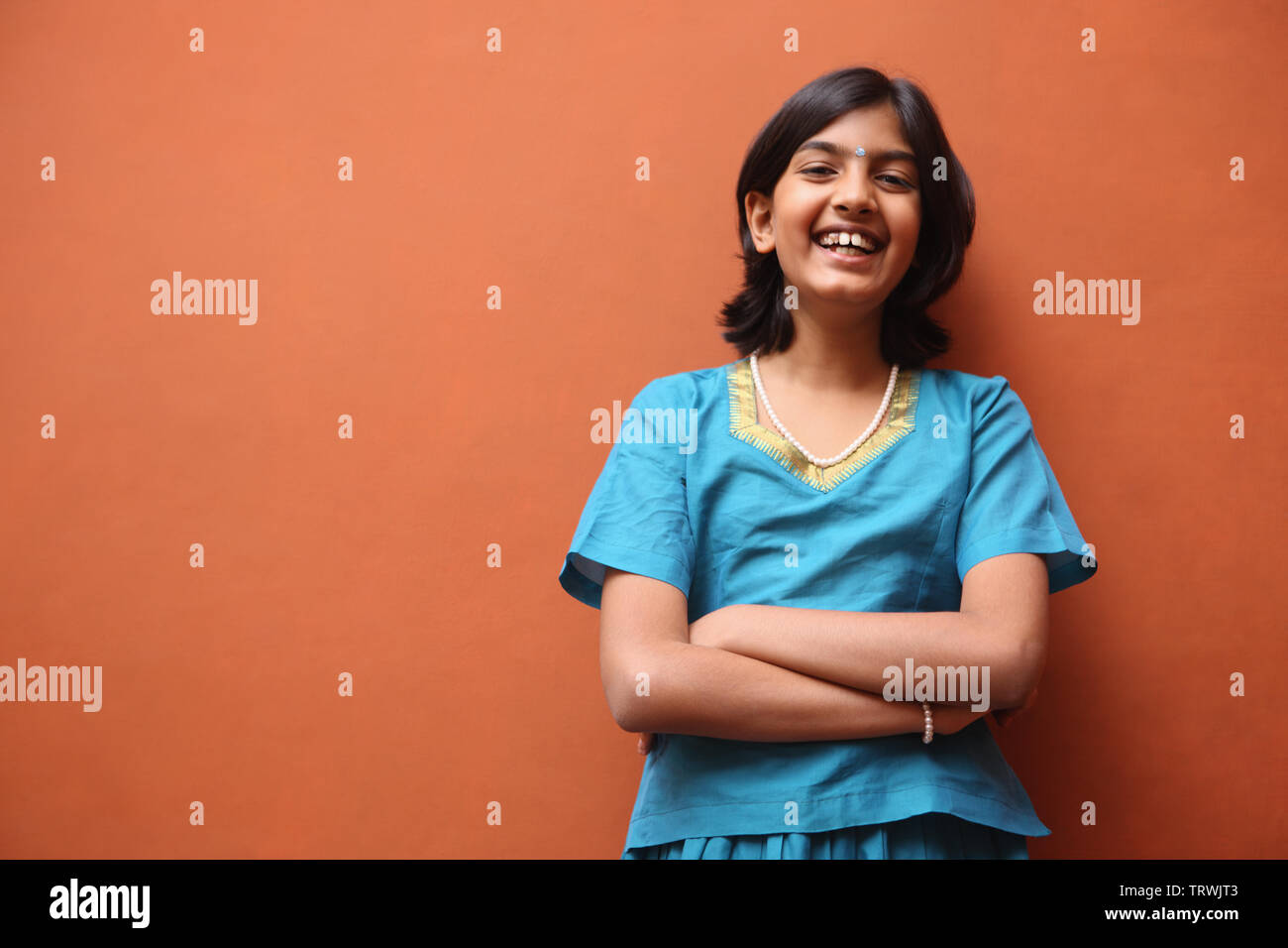 Portrait of a girl smiling with her arms crossed Stock Photo - Alamy
