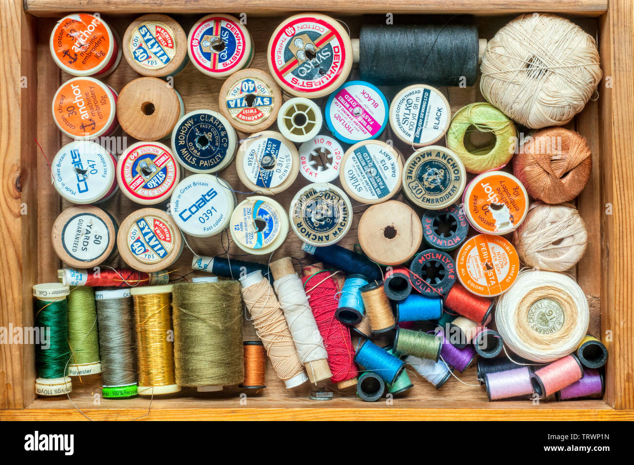 Haberdashery or sewing items stored in a drawer - reels of cotton and thread. Stock Photo