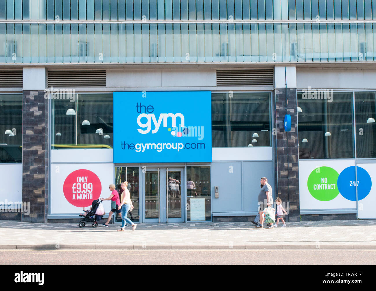 Front of the gym fitness centre with woman pushing pram and people walking past with shopping bags in Blackpool Lancashire England Stock Photo