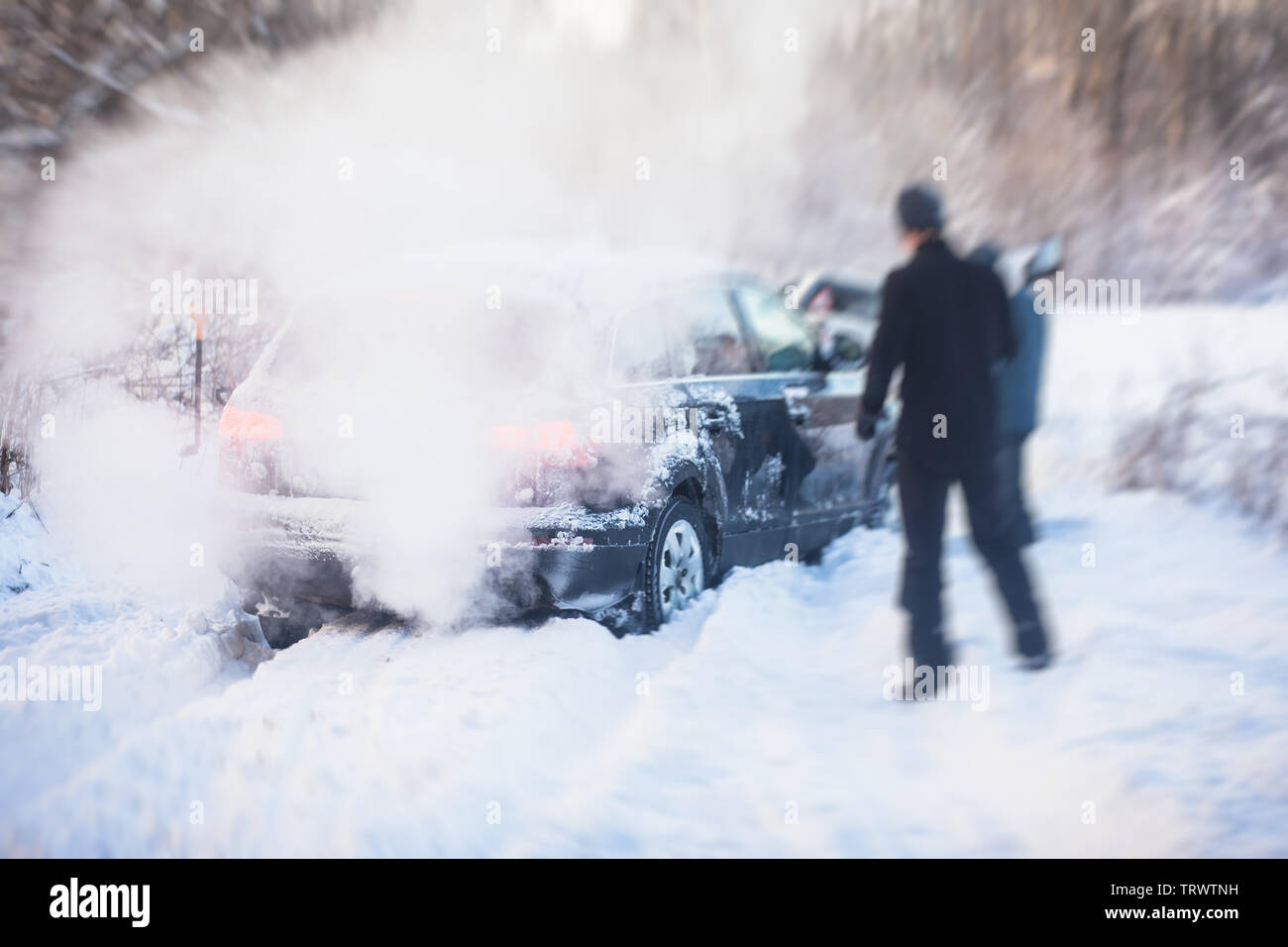 Process of taking out suv car stuck in snow, men digging and pushing the car out of snow