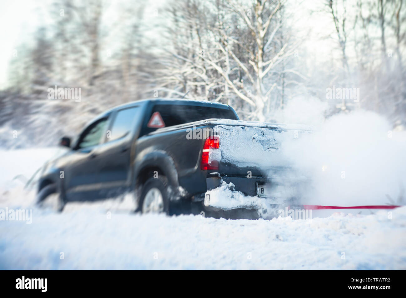 Process of taking out suv car stuck in snow, men digging and pushing the car out of snow