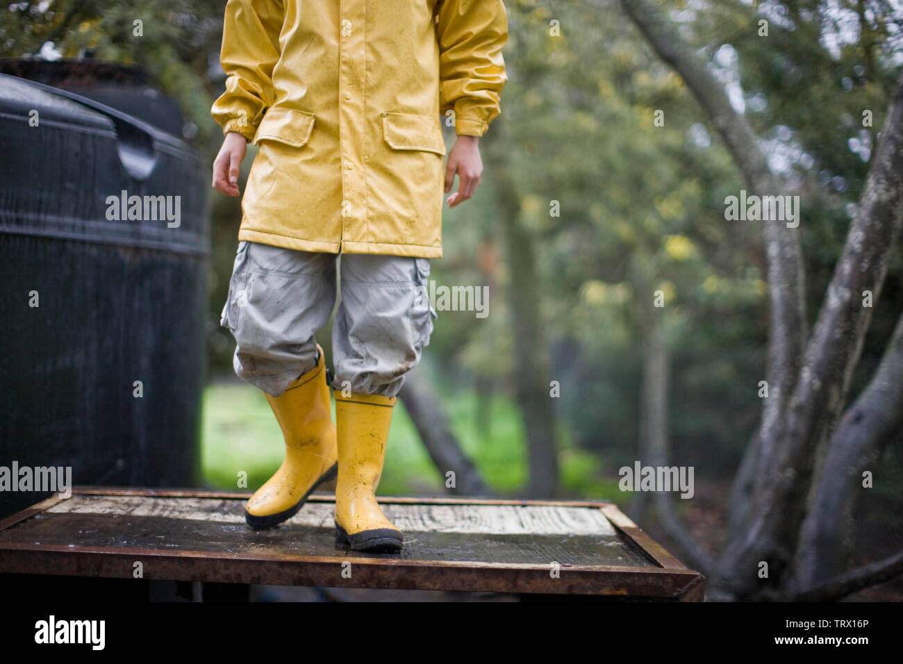 Boy wearing yellow raincoat and galoshes Stock Photo Alamy