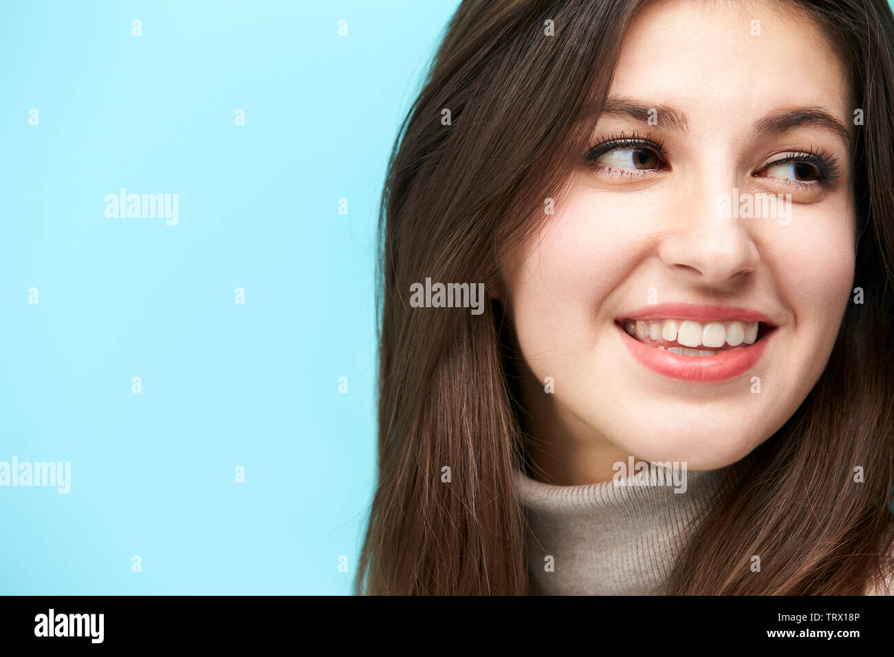 head shot portrait of a young caucasian woman isolated on blue background Stock Photo