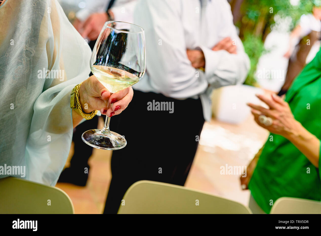 Older woman holding a glass of white wine at her retirement party Stock ...