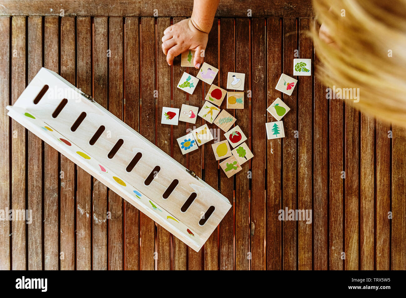 Child having fun with an educational wooden game at school, to make
