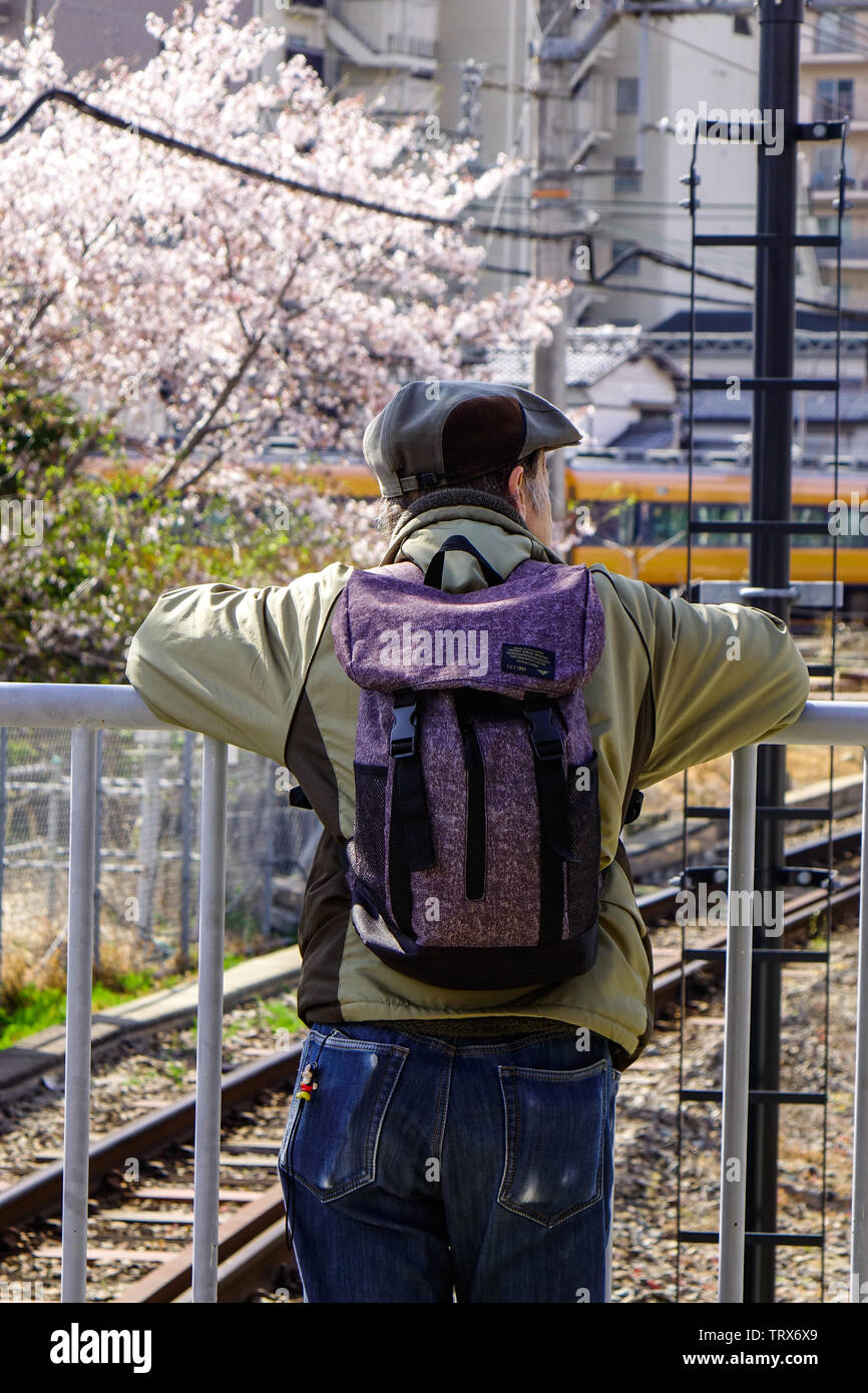 Osaka, Japan - Apr 18, 2019. A man standing at railway station in Osaka, Japan. Trains are a very convenient way for visitors to travel around Japan. Stock Photo