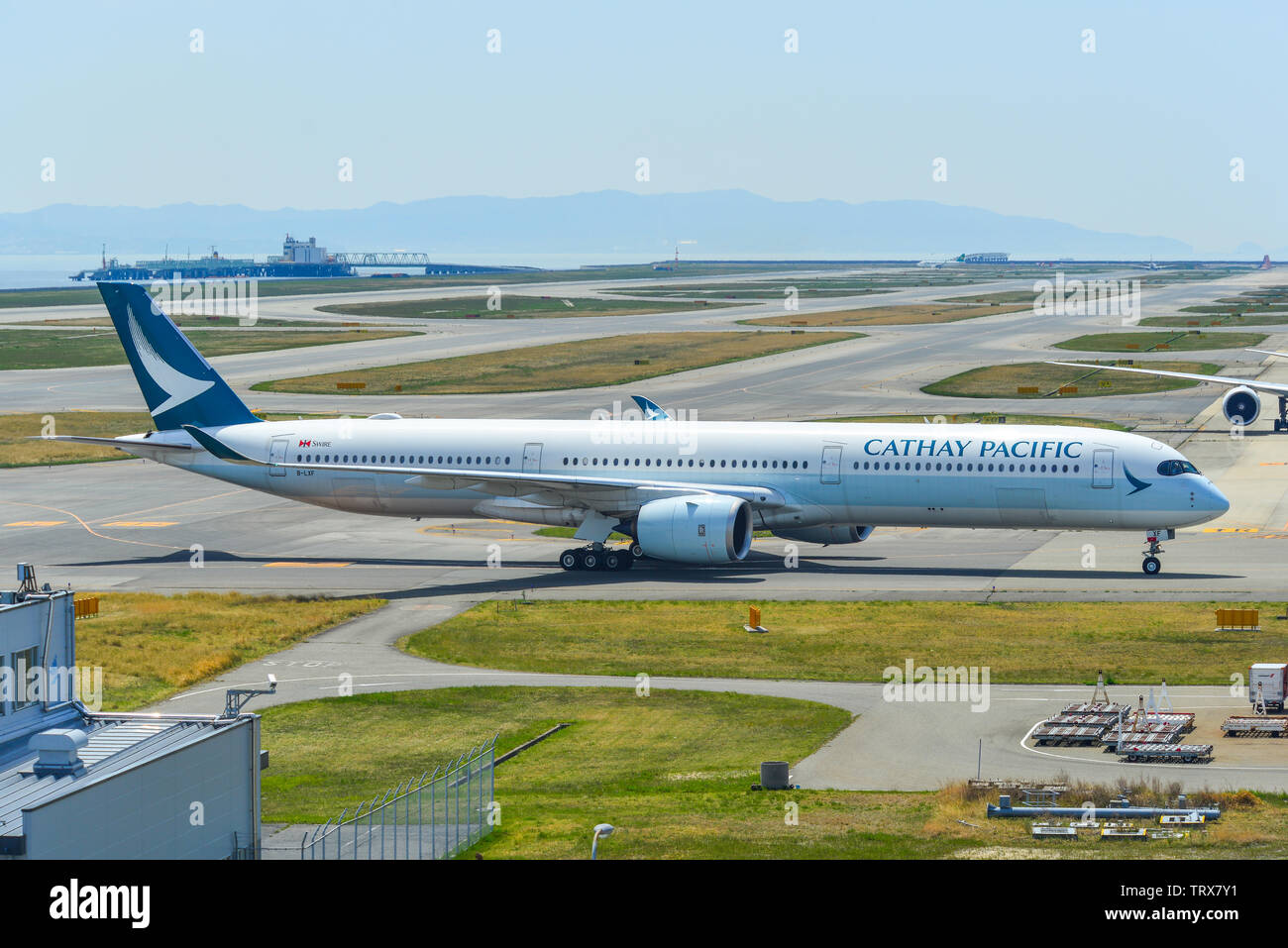 Osaka, Japan - Apr 19, 2019. Cathay Pacific B-LXF (Airbus A350-1000) taxiing on runway of Kansai Airport (KIX). The airport located on an artificial i Stock Photo
