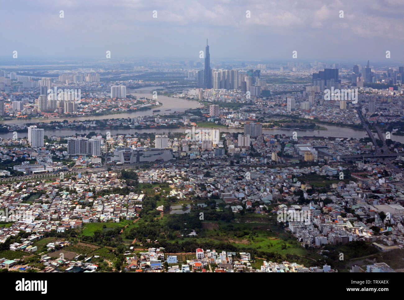 Arriving into Ho Chi Minh City, Vietnam - an aerial cityscape panorama featuring the Saigon River and tower. Stock Photo