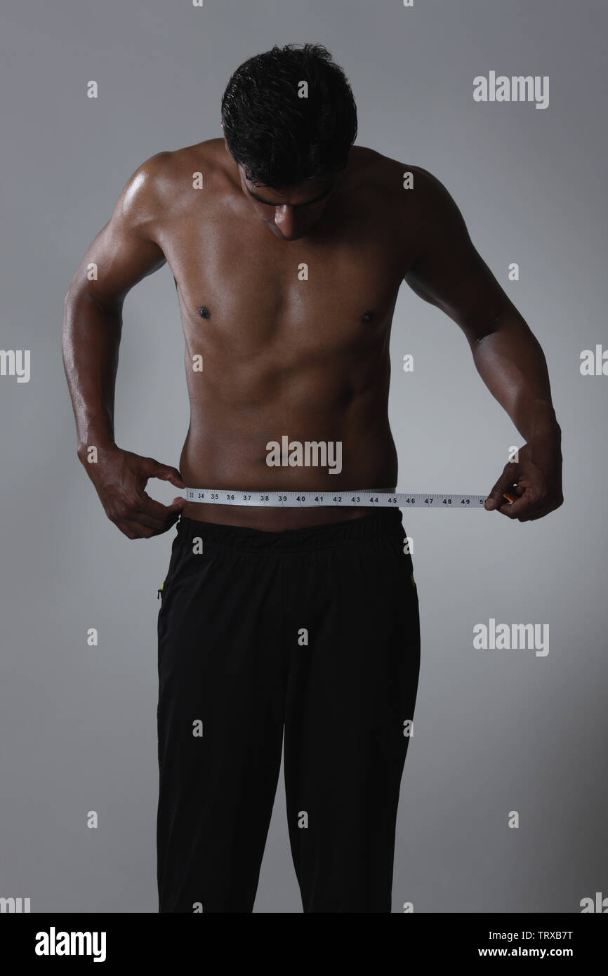 Image of muscular man measure his waist with measuring tape in centimeters  Stock Photo - Alamy