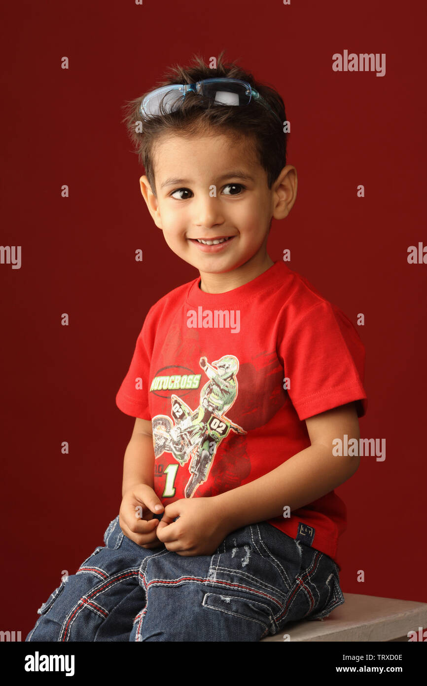 Boy sitting on a stool and smiling Stock Photo - Alamy