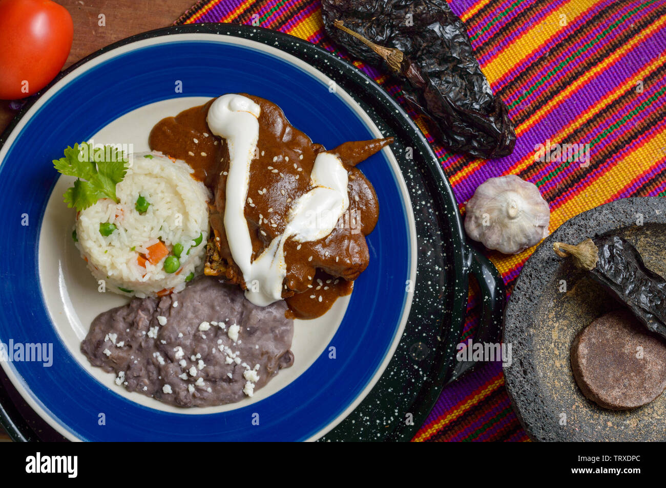 Mexican mole sauce with chicken, rice and black refried beans. Served