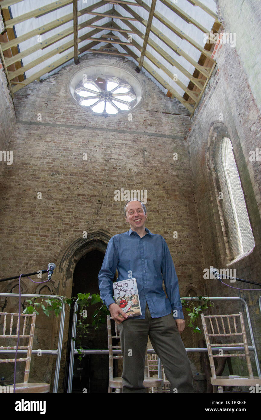 Author Lee Jackson with his book Palaces of Pleasure - How the Victorians invented mass entertainment in Abney Park Cemetery Mortuary Chapel Stock Photo