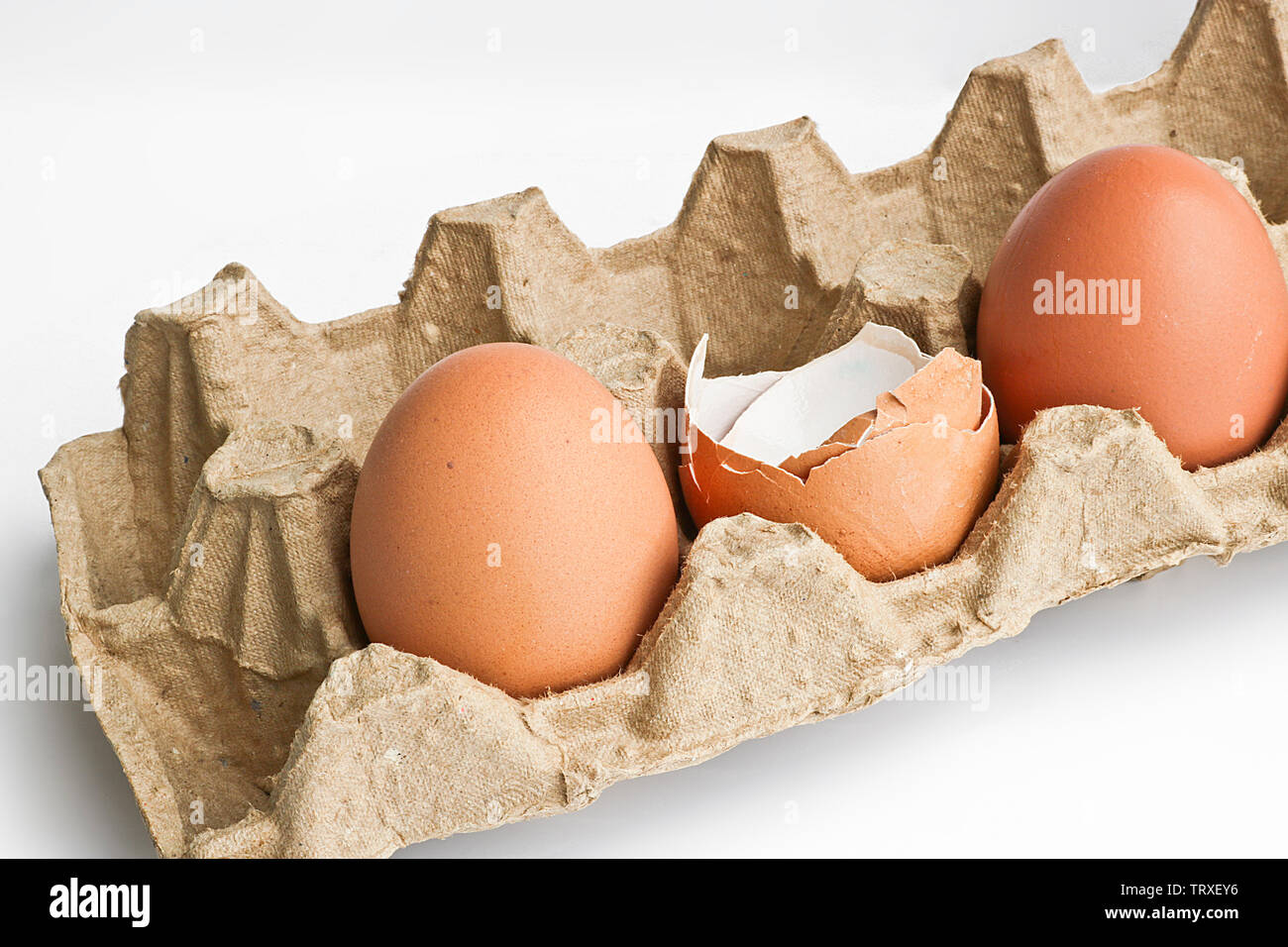 Carton packaging for eggs with broken eggshell and eggs on a light background. Organic concept Stock Photo