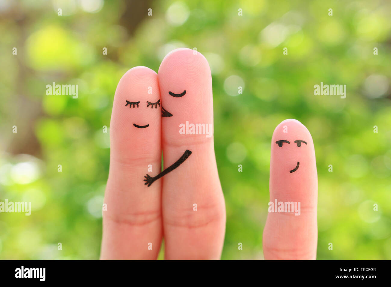 Fingers art of happy family. Concept of couple kisses, child glances after them. Stock Photo