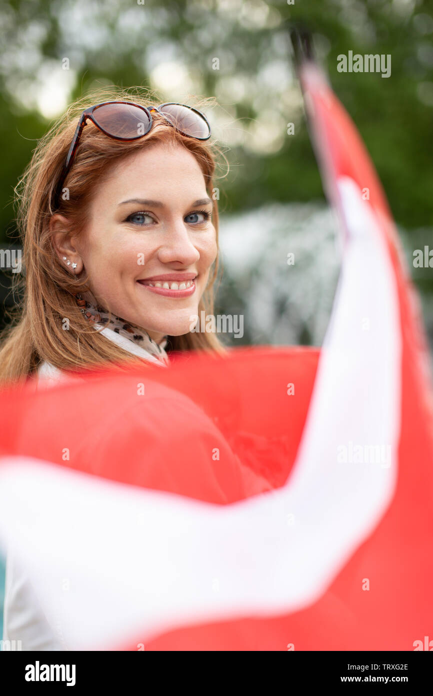 Happy young natural woman with smile holding flag of Austria park Stock Photo