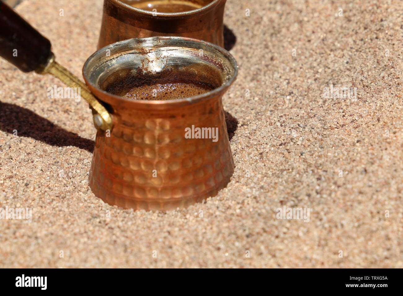 Preparation of traditional turkish coffee in cezve on hot sand Stock