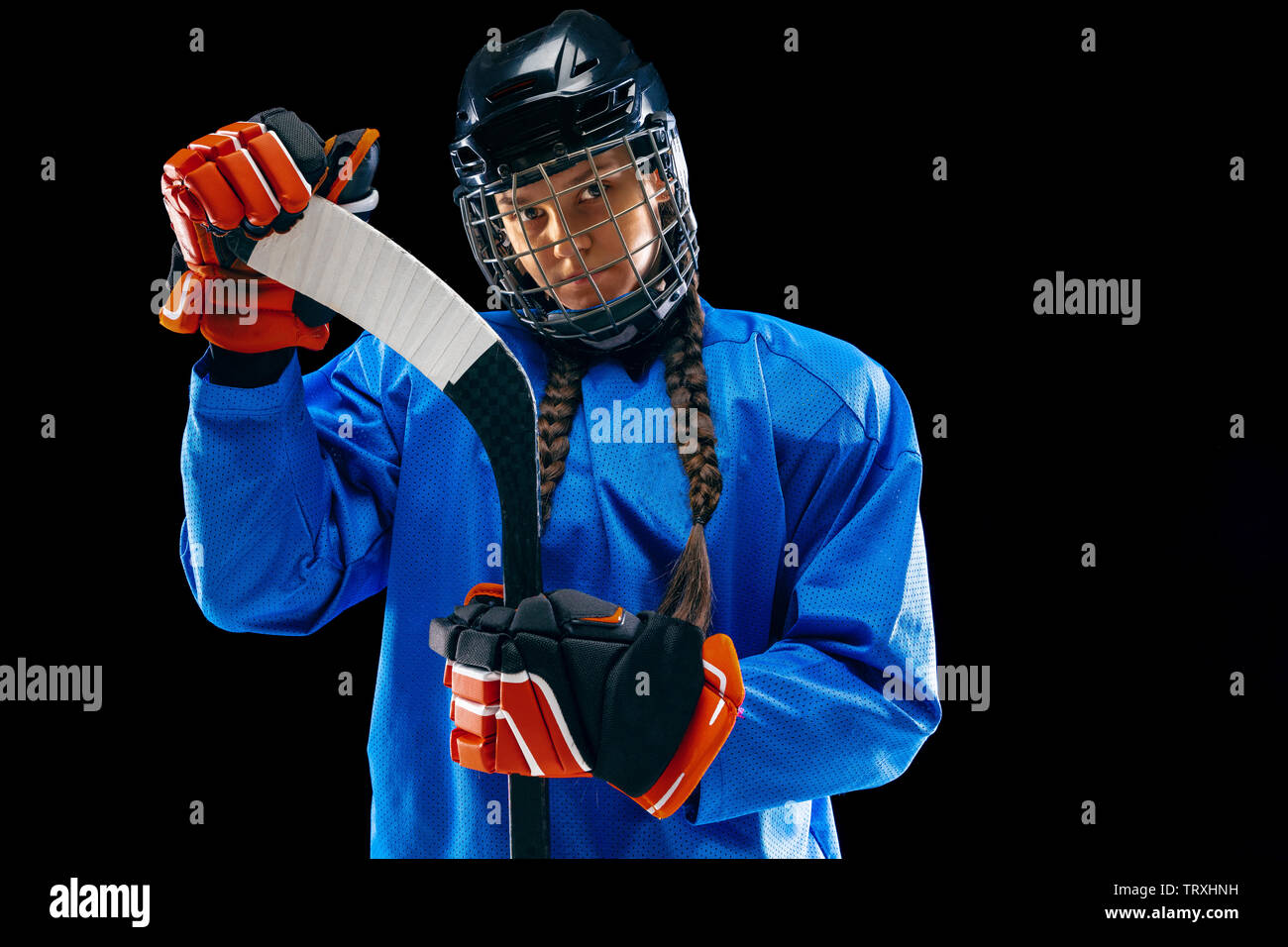 Male player holding ice hockey stick while standing at rink Stock Photo -  Alamy