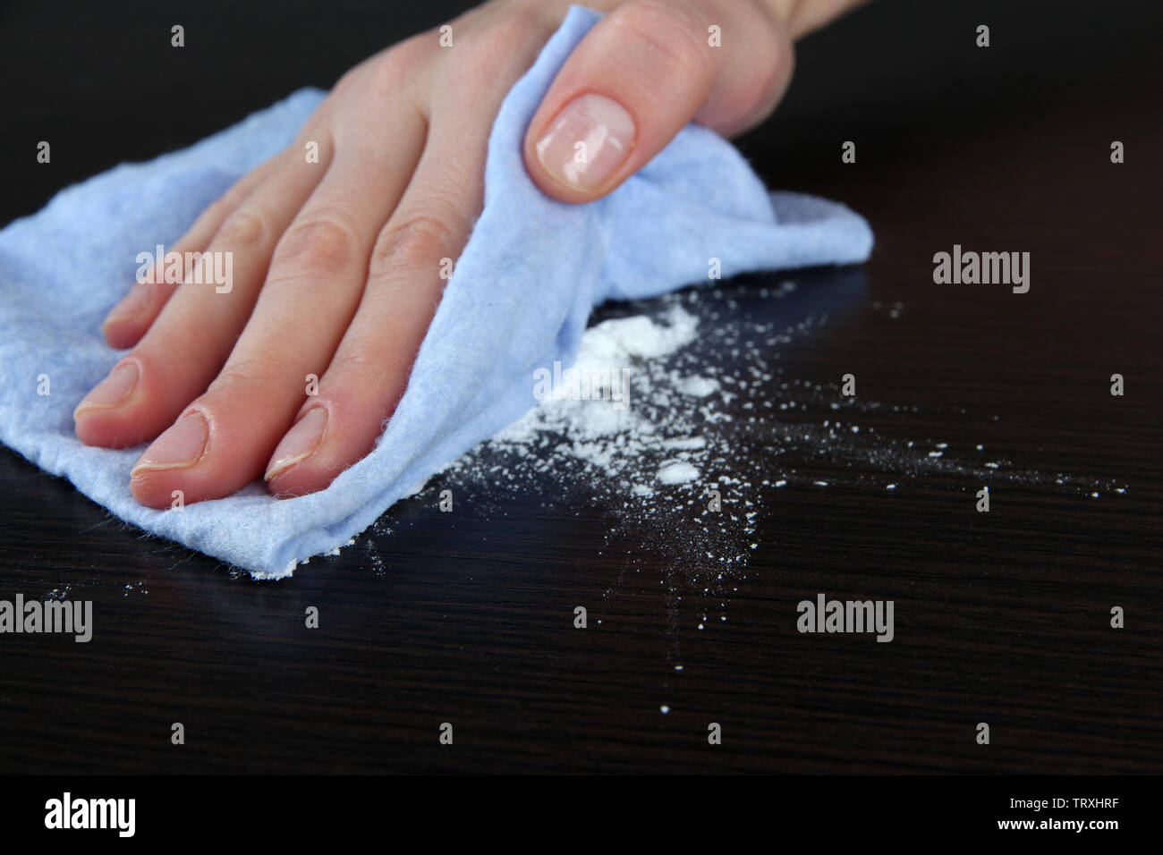 Hand wiping wooden surface with blue rag Stock Photo - Alamy